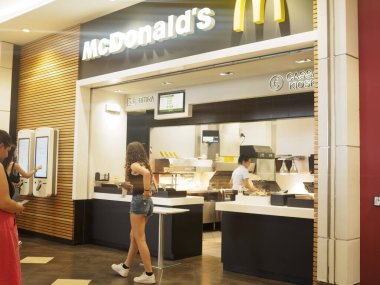 Cremona, İtalya 29 Temmuz 2024 Kendi siparişlerini veren müşteriler bir fast food restoranında yemek hazırlayan bir çalışanla bekliyor.