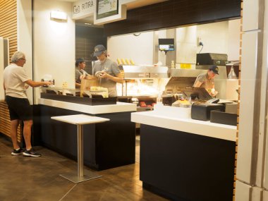 Cremona, İtalya 29 Temmuz 2024 Bir müşteri kasanın arkasında çalışan fast food restoran çalışanlarından yemek sipariş ediyor