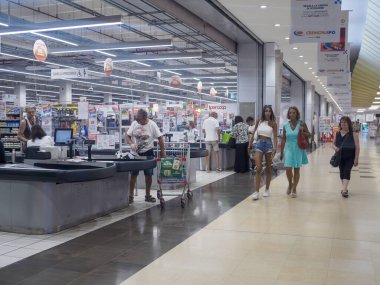 Cremona, İtalya 29 Temmuz 2024 Müşteriler bir süpermarketin kasasında kasiyerlerin çalıştığı bakkalların parasını ödüyor.