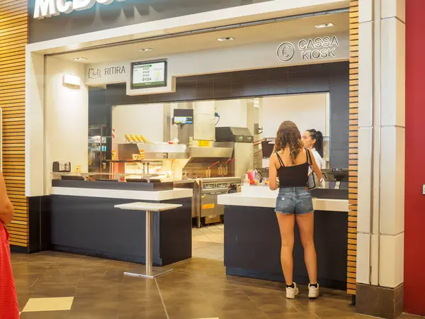 stock image Cremona, Italy July 29th 2024 A young woman is ordering food from a cashier at a fast food restaurant counter