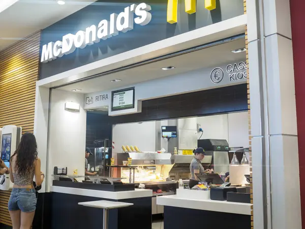 Cremona, İtalya 29 Temmuz 2024. McDonalds 'ın restoranından yemek siparişi veren genç bir kadın var.