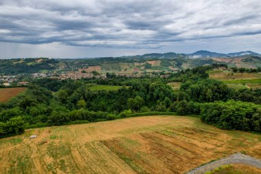 İtalya kırsalının panoramik manzarası. Tarlaları ve fırtınalı bir gökyüzünün altında küçük bir kasaba. Castell 'Arquato, Arda Vadisi, PC, İtalya