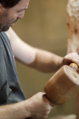 Atölyede tahta heykel ve keskiyle ahşap heykel oymada usta. Yaratıcılık ve ustalık sergiliyor.