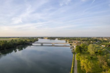 Gün batımında sakin çakıl yolu, sakin sulara yansıyan altın ışıkla birlikte, sakin bir manzara yaratıyor, Po Nehri, Piaceza, İtalya