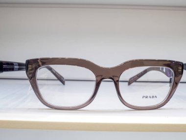 Kalın plastik çerçeveli kahverengi gözlük bir gözlükçünün rafında duruyor.