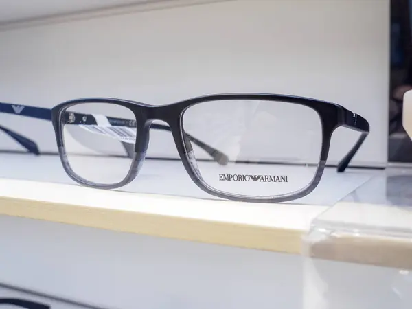 Siyah Emporio Armani gözlükleri bir gözlükçünün dükkanında rafta duruyor, müşterinin daha iyi görmesine yardım etmeye hazır.