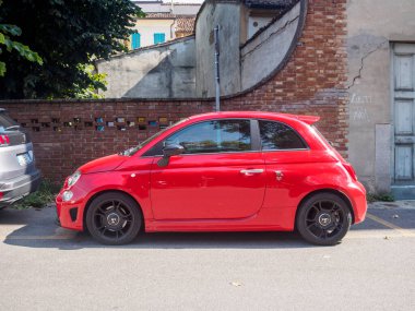 Cremona, İtalya 31 Ağustos 2024. Yazın sokağa park edilmiş 500 abarth kırmızı bir fiat. Spor tasarımı ve İtalyan mirası sergileniyor.