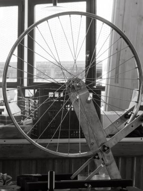 Bicycle mechanic centers a bicycle wheel on a truing stand, ensuring that the rim runs straight and true for optimal performance clipart