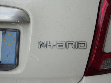 Cremona, İtalya 26 Eylül 2024 Bagaj kapağında hibrit sözcüğüne odaklanmış beyaz bir hibrit arabayı kapatın