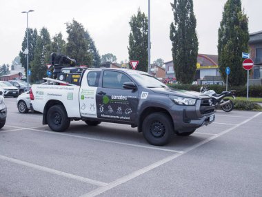 Cremona, İtalya 26 Eylül 2024 Haşere Kontrol Teknisyeni arkasında böcek ilacı püskürtme ekipmanı olan bir kamyonet kullanıyor.