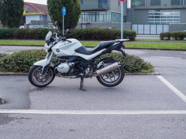 Cremona, İtalya 26 Eylül 2024 boş bir arsaya park etmiş beyaz bir motosiklet heyecanlı bir yolculuğa hazır.