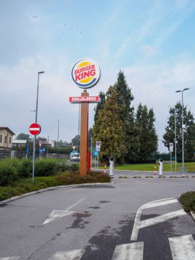 Cremona, İtalya 26 Eylül 2024 Bir Burger King tabelası bulutlu bir gökyüzüne karşı duruyor, İkonik logo ve King Drive tabelasını gösteriyor