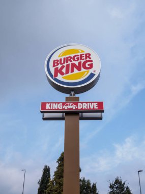 Cremona, İtalya 26 Eylül 2024 Bir Burger King tabelası bulutlu bir gökyüzüne karşı duruyor, İkonik logo ve King Drive tabelasını gösteriyor