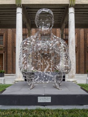 Cremona, Lombardy, İtalya 14 Ekim 2024 Modern metalik heykel, keman müzesinin avlusunda bulunan notalarla çalan bir müzisyeni temsil ediyor. 