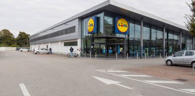Cremona, Lombardy, İtalya 14 Ekim 2024 Müşteriler bulutlu bir günde lidl süpermarkete bisikletle girip çıkıyorlar.