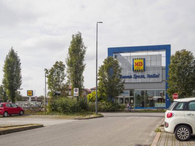 Cremona, Lombardy, İtalya 14 Ekim 2024 Otoparkı ve bulutlu bir günde insanların geçtiği bir MD süpermarket binasının önü