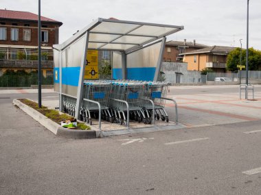 Cremona, Lombardy, İtalya 14 Ekim 2024 Birçok boş alışveriş arabası bir süpermarketin otoparkının çatısının altında müşterileri bekliyor.