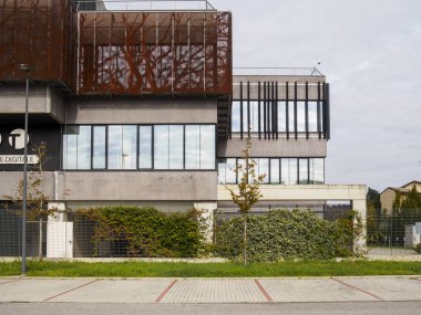 Cremona, Lombardy, İtalya 14 Ekim 2024 Benzersiz metal cepheli ve önünde boş bir park yeri olan modern bir ofis binası.