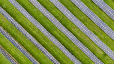 Güneş panellerinin sıraları güneşli bir günde temiz enerji üreterek büyüleyici bir geometrik desen yaratıyor. Görüntü, yenilenebilir enerji kaynaklarının giderek artan şekilde benimsendiğini vurguluyor
