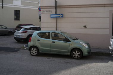 Cremona, Lombardy, İtalya 15 Ekim 2024 yeşil bir hatchback arabası Suzuki Alto arka planda mavi ve beyaz bir sokak tabelası ile İtalya 'da sokağa park edilmiştir.