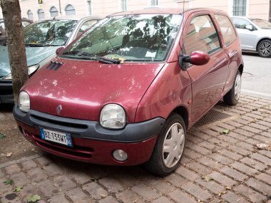 Cremona, Lombardy, İtalya 15 Ekim 2024 Küçük kırmızı renault twingo Avrupa 'nın tuğla sokağına park edilmiş, şehir park sorunları yaşanıyor