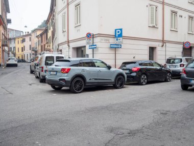Cremona, Lombardy, İtalya 15 Ekim 2024 Konut semtindeki dar bir cadde boyunca park halindeki arabalar, kentsel park zorluklarını ve şehir yaşamını gösteriyor
