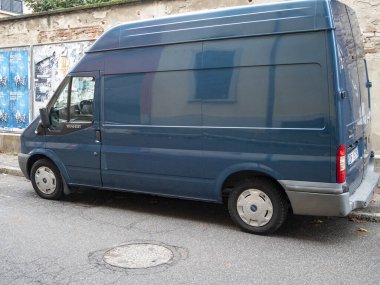 Cremona, Lombardy, İtalya. 15 Ekim 2024. Şehir sokağının kenarına park edilmiş mavi bir Ford transit minibüs. Teslimat ya da ticari amaçlar için kullanılmış olabilir.
