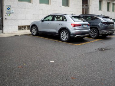 Cremona, Lombardy, İtalya 15 Ekim 2024 Belirlenmiş park alanlarını işgal eden gümüş ve gri geçitler, özel ya da özel bir park yeri ya da özel bir konut ya da ticari alana tahsis edilmiş