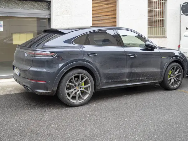 Cremona, Lombardy, İtalya 15 Ekim 2024 Modern elektrikli SUV Porsche cayenne coupe ve hibrit bir Avrupa şehir caddesi üzerine park edilmiş, parlak tasarımı ve çevre dostu teknolojisi sergilenmektedir.