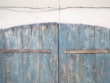 Close up of weathered wooden door with rusty metal hinges, capturing texture and decay of aged materials clipart