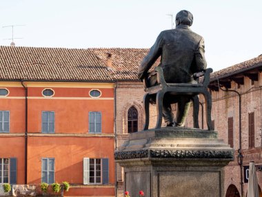 Busseto,Parma, Italy - November 3rd 2024 Rear view of Giuseppe Verdi bronze statue sitting on a chair in in main square clipart