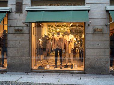 Cremona, Lombardy, İtalya 27 Ekim 2024 Zarif mankenler şık erkek giyim sergiliyor. Gelişmiş bir butik vitrin vitrininde, yoldan geçenler için göz alıcı bir sahne yaratıyor.