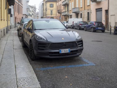 Cremona, Lombardy, İtalya 27 Ekim 2024 Modern gri Porsche Macan Tipik bir italyan kentsel caddesinde ücretli bir park yerine park etti