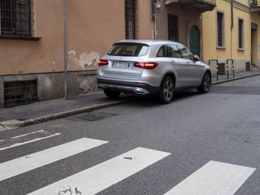 Cremona, Lombardy, İtalya 27 Ekim 2024 Silver Mercedes Benz Glc SUv Avrupa 'da dar bir yerleşim sokağında yaya geçidinin yakınına park etti.