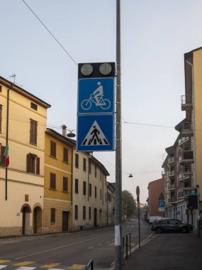 Cremona, Lombardy, İtalya 27 Ekim 2024 yaya geçidi ve bisiklet yolu tabelaları bir direğe monte edilmiş. Bu da yayalar ve bisikletçiler için yerleşim alanındaki güvenli bir geçiş noktasını gösteriyor.
