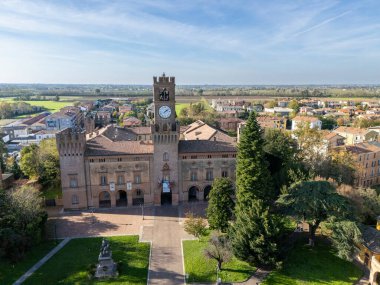 Busseto, Parma, Italy November 3rd 2024 Aerial view of palazzo orlandi torre, town hall, showcasing its clock tower and surrounding park clipart