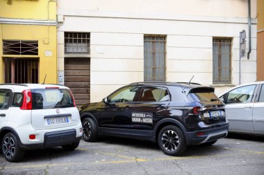 Cremona, Lombardy, İtalya - 7 Kasım 2024 Tipik bir italyan caddesinde park etmiş siyah bir okul arabası,