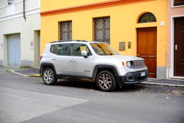 Cremona, Lombardy, İtalya - 7 Kasım 2024 Modern gümüş SUv turuncu bir konut binasının yakınına park edilmiş, kentsel araba sahibi ve taşımacılığı temsil ediyor.