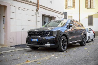 Cremona, Lombardy, İtalya - 7 Kasım 2024 Sleek Black Kia Sorento SUv Avrupa 'nın yan sokaklarından birine park etmiş, pencerelerindeki binaları yansıtıyor