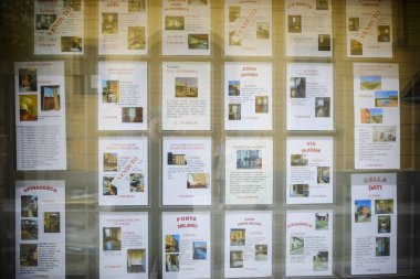 Cremona, Lombardy, İtalya - 7 Kasım 2024 Emlak acentesi vitrininde çok sayıda emlak listesi yer alıyor.