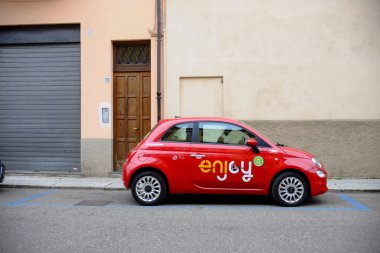 Cremona, genellikle - 6 Ekim 2024 Parlak kırmızı fiat 500 Bir yerleşim bölgesindeki belirlenmiş bir park yerine park etmiş araç paylaşımının keyfini çıkar