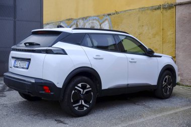 Cremona, Ially - 6 Ekim 2024 Stili beyaz peugeot 2008 SUv 1.2 puretech 130 hp motorlu, sarı bir duvara park edilmiş, modern tasarımını ön plana çıkarıyor