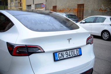 Cremona - 6 Ekim 2024 Beyaz Tesla modelinin arka görüntüsü 3 çift motorlu uzun menzilli şehir caddesinde park edilmiş, parlak tasarımı ve elektrik motoru sergilenmektedir.