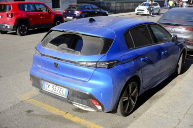 Cremona, Ially - 6 Ekim 2024 Yeni elektrikli peugeot 308 gt Tak hibrid şehirde park edilmiş, parlak tasarımı ve çevre dostu özellikleri arka pencereden vurgulanıyor