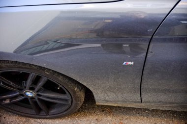 Cremona - 6 Ekim 2024 Tozlu gri bmw spor araba kapısının ayrıntıları, simgesel m logosunu gösteriyor ve aracın sportif estetiğini vurguluyor