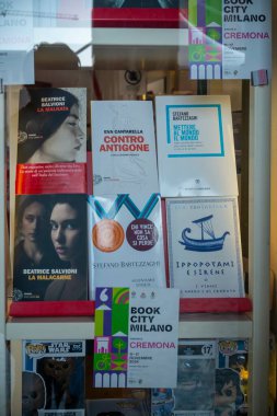Cremona, İtalya - 20 Kasım 2024 Kitapçı Penceresinde çeşitli yazarların kitapları ve bir poster reklam kitabı şehri Milano ve Cremona