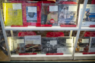 Cremona, İtalya - 20 Kasım 2024 Kitapevi penceresinde çeşitli sanat kitapları ve müzik notları sergileniyor, tanınmış sanatçılar ve besteciler hakkında başlıklar sergileniyor