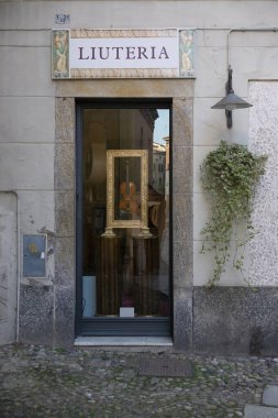Cremona, İtalya - 20 Kasım 2024 Güzelce hazırlanmış bir keman geleneksel İtalyan Luthier 'in dükkanının vitrininde duruyor.