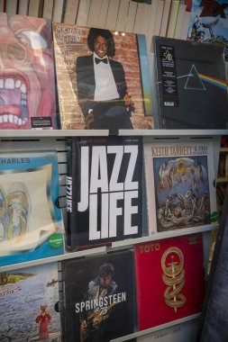 Cremona, Italy - November 27th 2024 Vinyl records showcasing iconic artists like michael jackson, pink floyd, and bruce springsteen are displayed on a rack in a bookstore in cremona, italy clipart