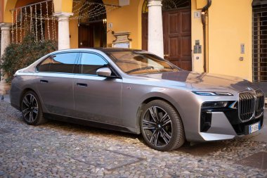 Cremona, Lombardy, İtalya - 27 Ekim 2024 Modern elektrikli bmw i7 xdrive 60 sedan tarihi bir binanın yakınına park edilmiş, lüks ve sürdürülebilirlik sergiliyor